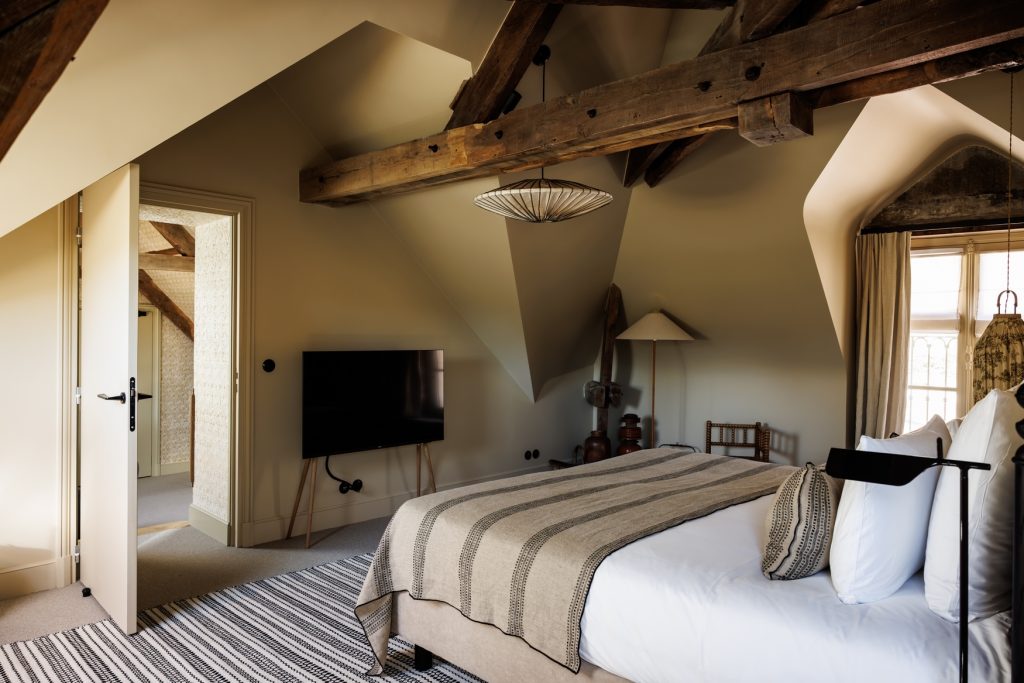 chambre avec lit double, poutres en bois, lustre en papier et television de la junior suite mer de l'hotel de luxe en bretagne