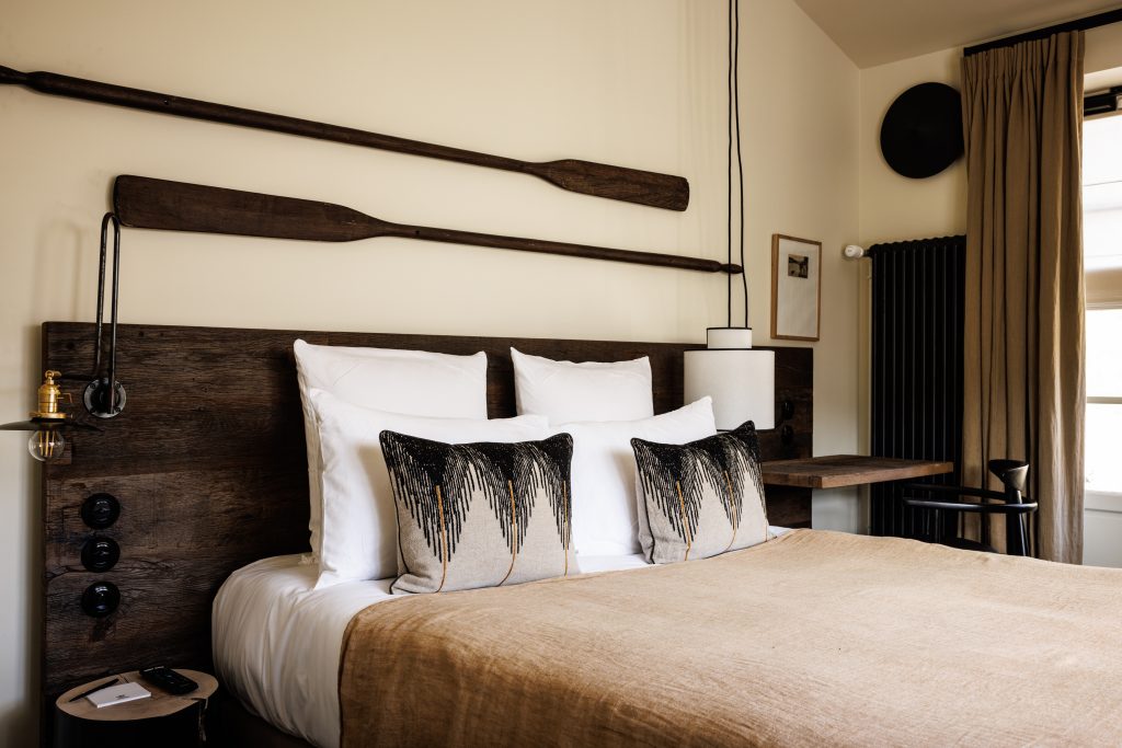 Cosy park room decorated with wooden oars and king size bed with wooden headboard in our luxury hotel relais et chateau morbihan in bretagne