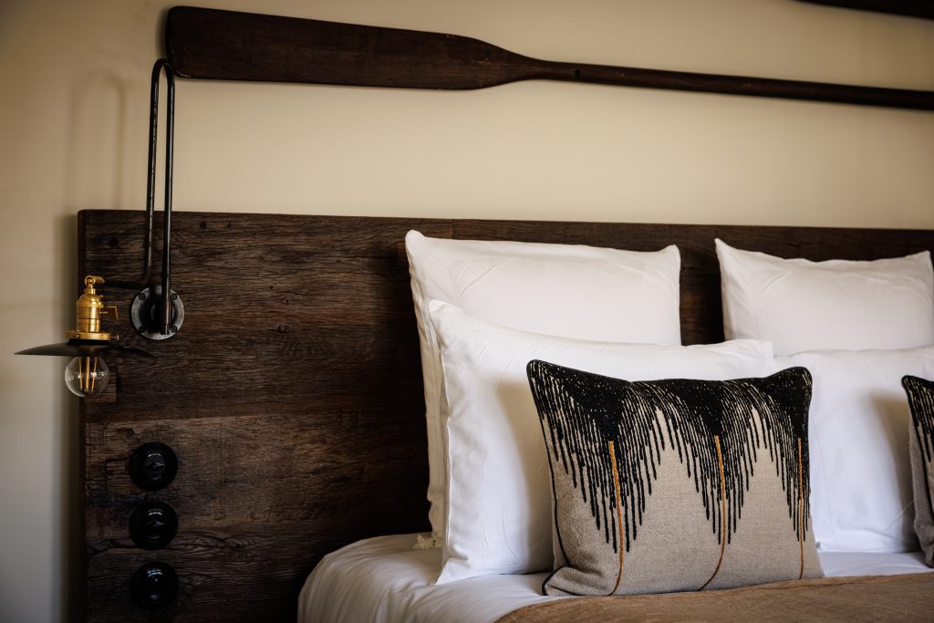 Room decorated with wooden oars and king size bed with wooden headboard in the cosy famille parc room of our luxury hotel relais et chateau morbihan in bretagne